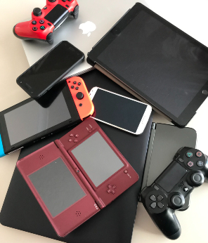 Disposing of unwanted tech items - pile of unwanted technology such as phones, Nintendo DS and playstation